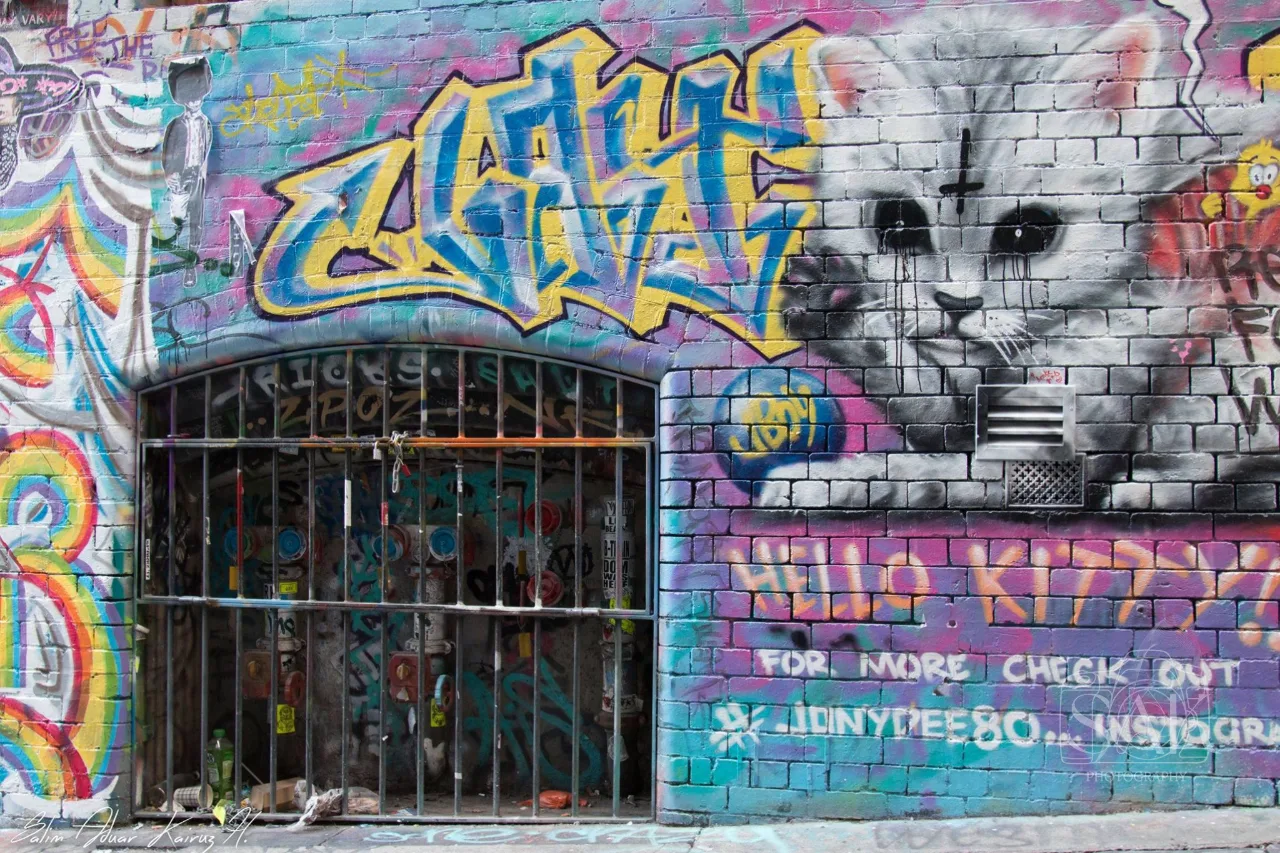 Graffiti mural of a cat painted around a barred window
